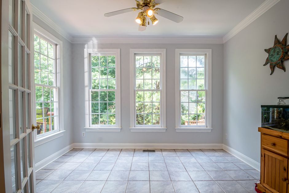 A bright interior room with large glass windows and a tiled floor.